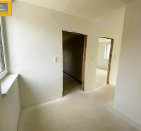 Interior of a 5 or more room apartment with white walls and windows, awaiting completion.