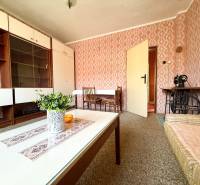 Living room with retro wallpaper, wooden furniture, and a sewing machine in a family house.