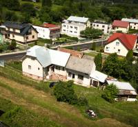 A family house in Konská surrounded by greenery and neighboring houses, aerial view.