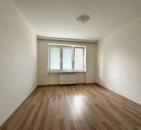 An empty room with a wooden floor and a window in a two-room apartment.