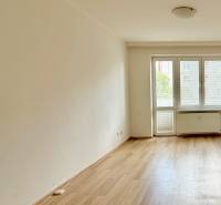 A room with a wooden floor and windows in a 2-room apartment, light penetrates inside.