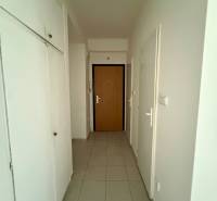 A hallway with pale walls and floor tiles in a 2-room apartment.