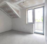 An interior in a family house with unfinished walls and large windows, without furniture.