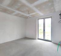 Empty room in a family house with white walls and large windows.
