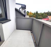 The balcony of a family house in Zemianska Olča with a view of greenery and rooftops.