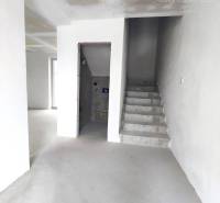 Interior of a family house with concrete stairs and plastered walls ready for finishing.