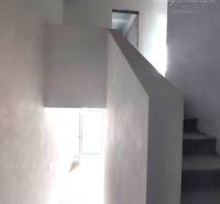 Interior of a family house with white walls, a staircase, and air conditioning.