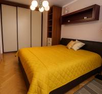 Bedroom in a 2-room apartment with a double bed, wardrobe, and hanging light fixture.