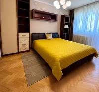 Bedroom with a double bed and a yellow blanket in a two-room apartment.