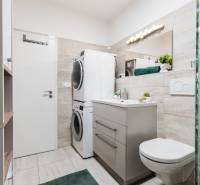 Bathroom with a washing machine and dryer in a 2-room apartment, modern tiles and sanitary ware.