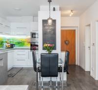 A kitchen in a 2-room apartment with a dining table and colorful tiles.