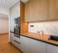 A kitchen in a 3-room apartment with a wooden decor and built-in appliances.