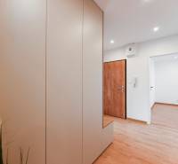 Entrance hallway in a 3-room apartment with wooden doors and storage space.