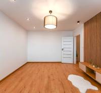 Living room in a 3-room apartment with wooden floors and a decorative wall.