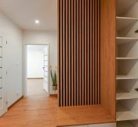 Hallway in a 3-room apartment with wooden elements and open shelves.