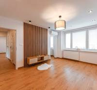 Living room in a 3-room apartment with wooden flooring and a wall panel.