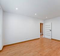 A room with light walls, wooden floor, and a window in a 3-room apartment.