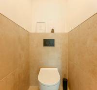 A simple toilet with beige tiles in a 3-room apartment.