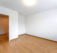 Empty room with light walls and wooden floor in a 3-room apartment.