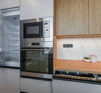 A kitchen in a 3-room apartment with a refrigerator, microwave, and dishwasher.