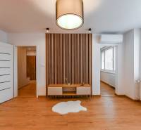 Wooden floor and accent wall with slats in the interior of a 3-room apartment.