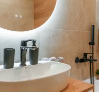 Bathroom in a 3-room apartment with a sink, modern mirror, and matte fixtures.