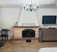 A room with a television and a dresser in a family house with wooden flooring.