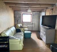 The family house offers a comfortable living room with a leather sofa and a television.