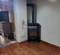 Interior of a family house with a tiled stove, light, and tiles.