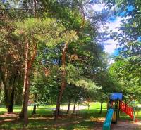 A playground in the middle of trees in the Juh housing estate in Trenčín.