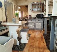 Interior of a family house with kitchen furniture, wooden floor, and dining table.