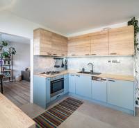 A kitchen in a 3-room apartment with wooden cabinets and built-in appliances.