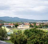 View from a 3-room apartment on 1. mája Street in Pezinok, surrounded by greenery and hills.