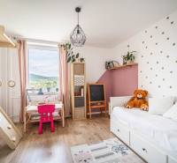 Children's room in a 3-room apartment with toys, a table, and decorations.