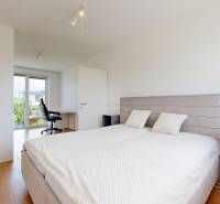 A bright bedroom with a bed, nightstands, and a view of the garden in a 3-room apartment.