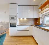 A kitchen in a 3-room apartment with a light-colored kitchen unit and built-in appliances.