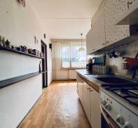 The kitchen in a 4-room apartment with a bright interior, modern stove, and wooden floor.
