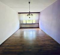 Living room in a 4-room apartment with wooden flooring and a large window.