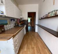A kitchen in a 4-room apartment with patterned cabinets and a shelf with glasses.