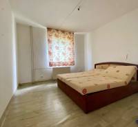 A bedroom with a bed and floral curtains in a 4-room apartment.