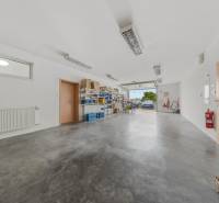 A spacious garage in a family house with shelves and open doors.