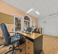 Office in a family house with a wooden desk, chair, computer, cork board.