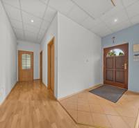 A hallway in a family house with wooden floors, doors, and entry elements.