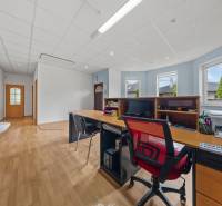 Office in a family house with a desk, computer, and wooden floor.
