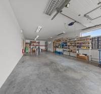 Storage space in a family house with shelves and an open garage door, boxes with material.
