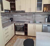 A kitchen in a 4-room apartment with cream cabinets and stainless steel appliances.