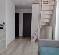 Interior of a 4-room apartment with light floors, staircase, and doors.