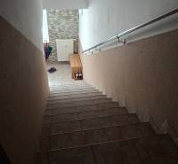 Staircase in a 4-room apartment, tiles and railing, hallway with radiator.