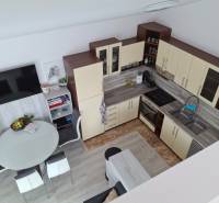 A kitchen in a 4-room apartment with a dining table and built-in wardrobes.