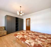 Bedroom in a 2-room apartment with a bed, wardrobe, and armchair.